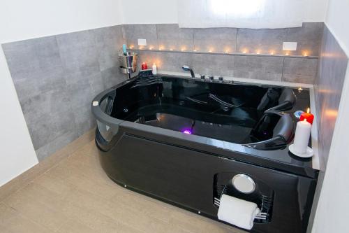 a bathroom with a black bath tub with a sink at B&B Piazza Duomo in Cerignola