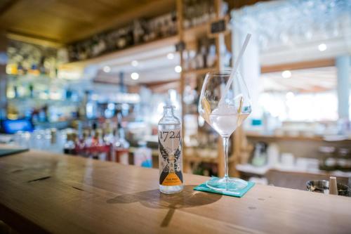 a bottle of wine and a glass on a table at Berghotel - Sexten in Sesto