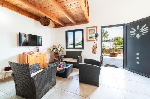 a living room with wicker chairs and a tv at Liane de jade location in Le Tampon