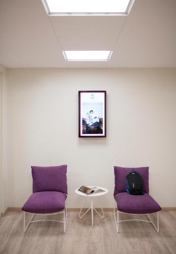 two purple chairs and a table in a room at ibis Styles Athens Routes in Athens