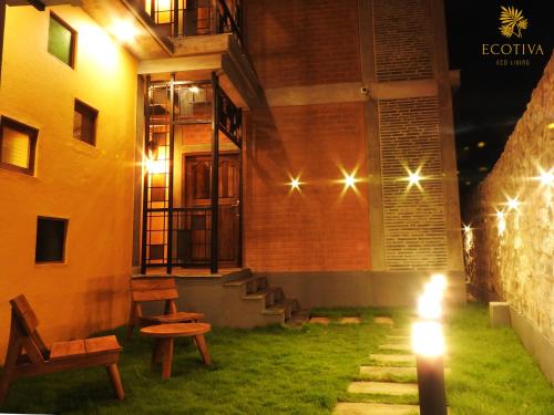 a building with a yard with benches and lights at Villa Ecotiva in Puducherry