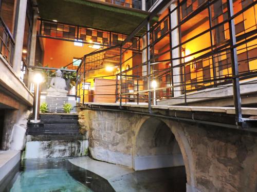 a bridge over a river with a statue in a building at Villa Ecotiva in Puducherry