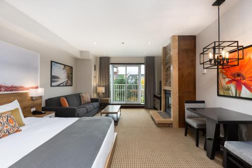 um quarto de hotel com uma cama e uma sala de estar em Ermitage du Lac em Mont-Tremblant