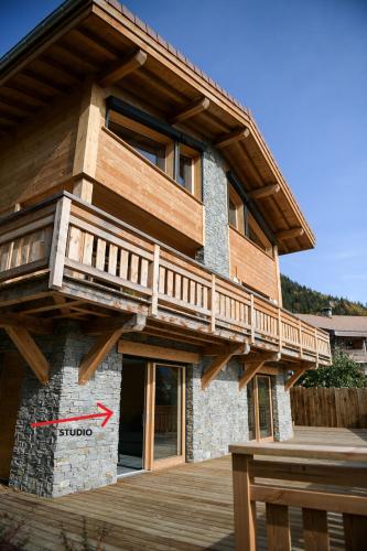 une maison avec une terrasse sur le côté dans l'établissement Le Mazot d'la Marmotte Studio, à Passy