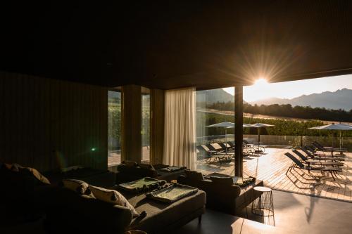 a living room with couches and a balcony with a patio at Design Hotel Tyrol in Rablà