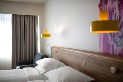 a hotel room with a bed and a chair at ibis Styles Athens Routes in Athens