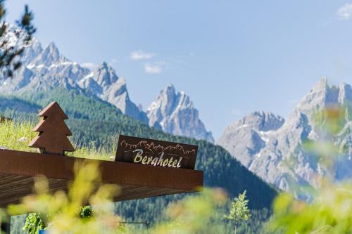 a sign with a mountain range in the background at Berghotel - Sexten in Sesto