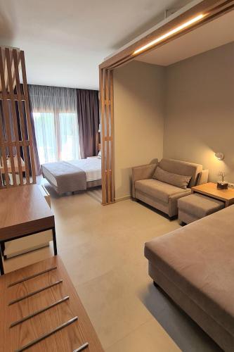 a living room with a couch and a bed at Palladium Hotel in Kriopigi