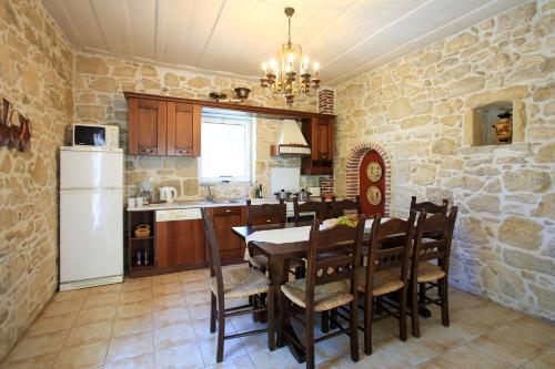 a kitchen with a table and chairs and a white refrigerator at Villa Oasis in Kamilari