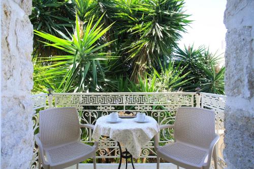 a table and chairs on a patio with palm trees at Villa Oasis in Kamilari