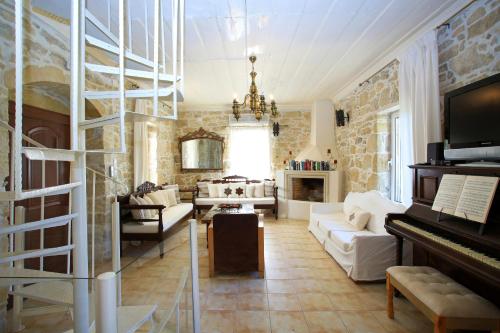 a living room with a couch and a piano at Villa Oasis in Kamilari