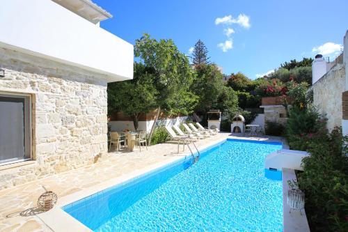 a villa with a swimming pool in a yard at Villa Oasis in Kamilari