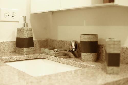 a kitchen counter with a sink and a faucet at Aruba Smart Apartments in Palm-Eagle Beach