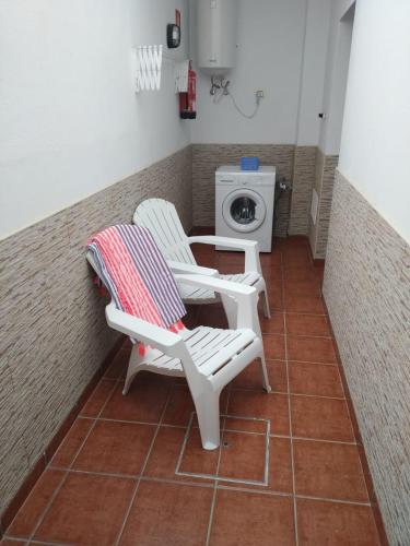 two white chairs and a washing machine in a bathroom at CHEGAMOS in Punta de Mujeres