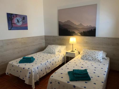 two twin beds in a room with a picture on the wall at CHEGAMOS in Punta de Mujeres