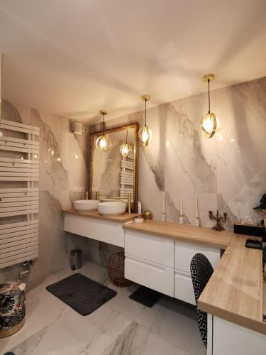 une salle de bain avec un lavabo et un miroir dans l'établissement Villa l'hermine Vue mer exceptionnelle, prestation luxe contemporaine avec cinema et spa, borne voit électrique, à Perros-Guirec