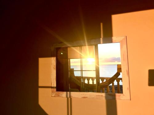 uma vista para o oceano a partir de uma janela com o pôr-do-sol em Playa Paraiso em Costa Calma