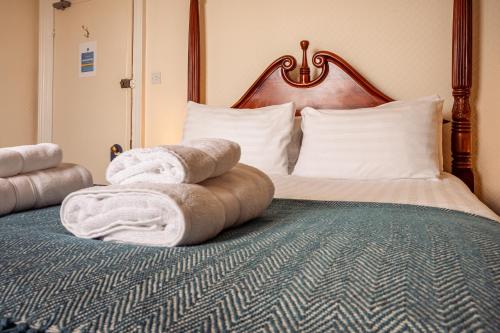 a hotel room with a bed with towels on it at Manor House Hotel Holy Island in Berwick-Upon-Tweed