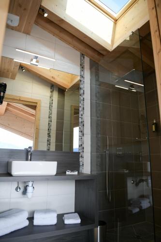 une salle de bain avec un lavabo et une douche en verre dans l'établissement Le Mazot d'la Marmotte T3, à Passy