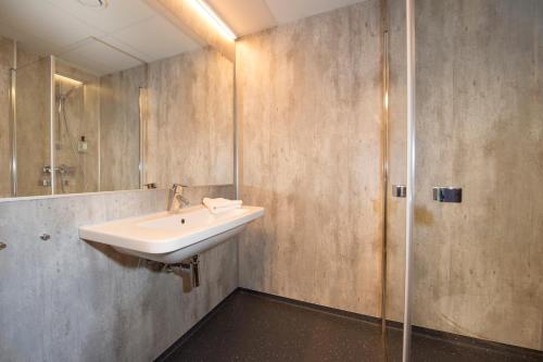 ein Bad mit einem Waschbecken und einer Dusche in der Unterkunft Svalbard Hotell | The Vault in Longyearbyen