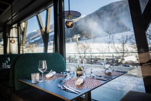 a table in a restaurant with a view of the mountains at Gourmet AlpinHotel Sonnleiten in Cadipietra