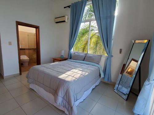 a bedroom with a bed and a window and a mirror at Hidden Paradise at Apto Del Cerro in Santa Bárbara de Samaná