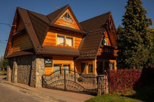 a large wooden house with a black roof at U Zbyszka in Białka Tatrzańska