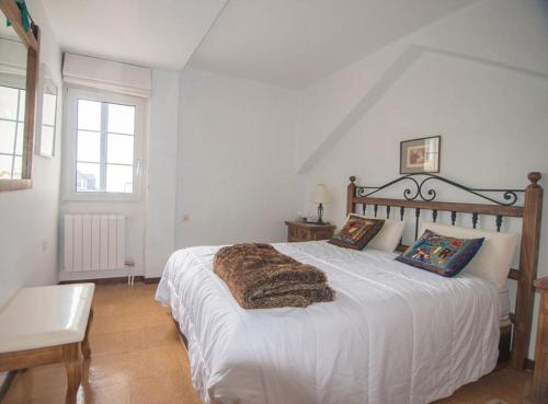 Un dormitorio con una cama blanca con una manta peluda. en IMEDA DÚPLEX El MADROÑO, en Sierra Nevada