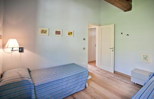 a bedroom with a bed and a door to a hallway at Spa Resort Fonte Alla Lepre in Riparbella