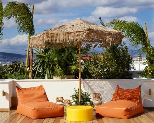 a patio with two chairs and an umbrella at Brown Acropol, a member of Brown Hotels in Athens