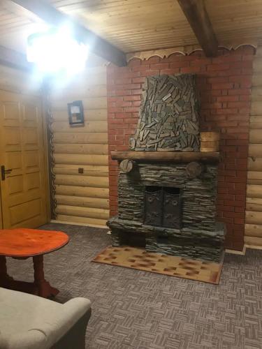 a living room with a brick fireplace and a table at Panorama Karpat in Yablunytsya
