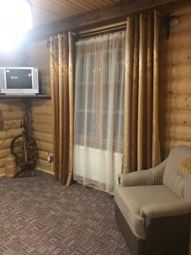 a living room with a couch and a television at Panorama Karpat in Yablunytsya