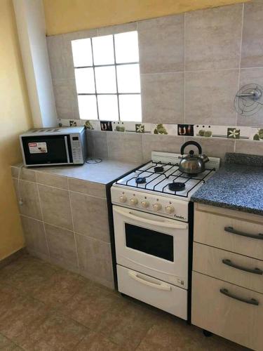 a kitchen with a white stove and a microwave at Atlantis Park in Mar de Ajó