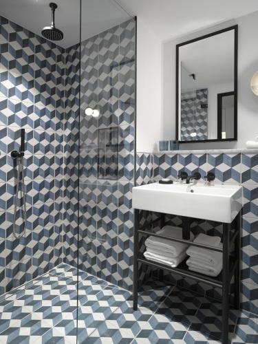 a bathroom with a sink and a shower at Kimpton De Witt Amsterdam by IHG in Amsterdam