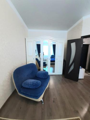 a room with a blue chair and a mirror at Однокомнатная квартира: ЖК Сенатор in Astana