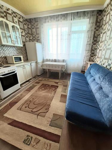 a living room with a blue couch in a kitchen at Однокомнатная квартира: ЖК Сенатор in Astana
