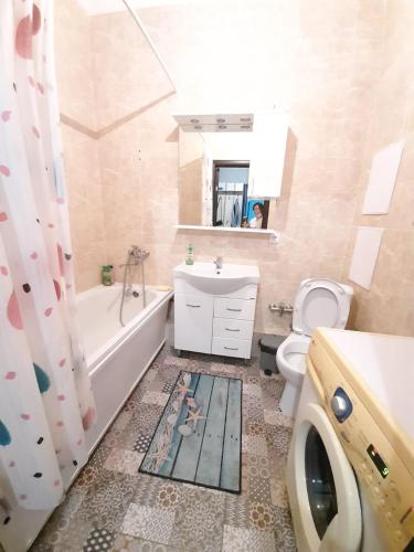 a bathroom with a tub and a toilet and a sink at Однокомнатная квартира: ЖК Сенатор in Astana