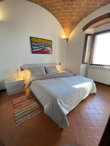 a bedroom with a large bed and a window at Frantoio-di-Campiglia in Campiglia Marittima