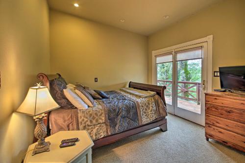 Un dormitorio con una cama, un televisor y una mesa. en Dock, Hot Tub and Kayaks Luxe Hot Springs Lakehouse, en Hot Springs