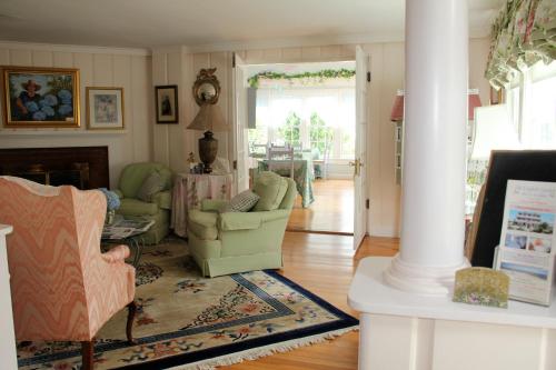 a living room with two chairs and a fireplace at An English Garden in Dennis Port