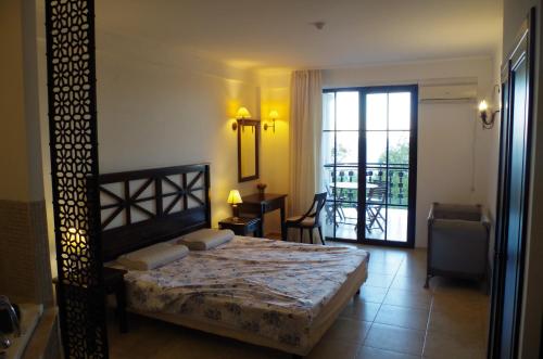 1 dormitorio con 1 cama y puerta a un balcón en Beautiful 1st-Line Seaview Private Appartement in The Cliff resort, en Obzor