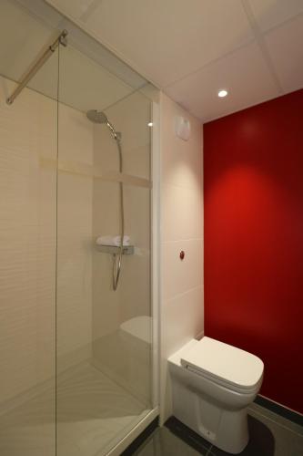 a bathroom with a toilet and a glass shower at Hotel Arena Toulouse in Toulouse