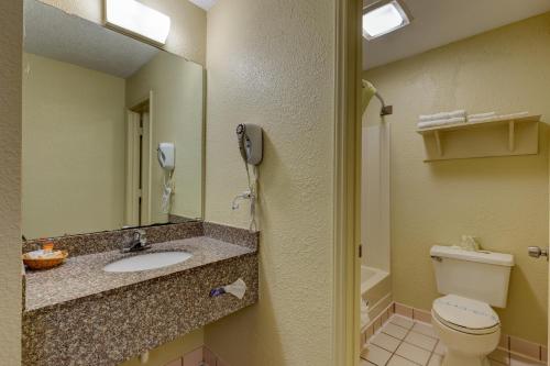 a bathroom with a toilet and a sink and a phone at Continental Inn - Charlotte in Charlotte