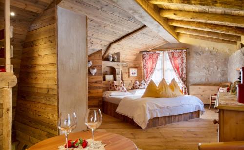 a bedroom with two beds and wine glasses on a table at Chalet Sogno di Fiaba in Nembia