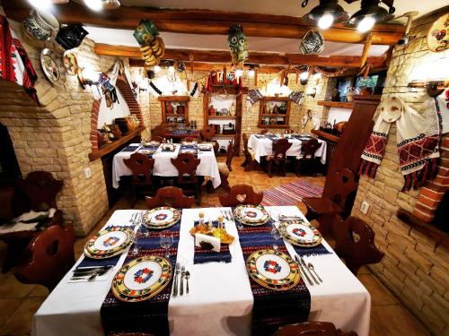 a dining room with tables and plates of food at Crama Haiducilor in Cluj-Napoca