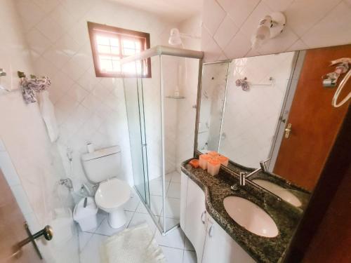 a bathroom with a sink and a toilet and a shower at Chalé aconchegante na Serra Pernambucana - Em condomínio - Gravatá in Gravatá