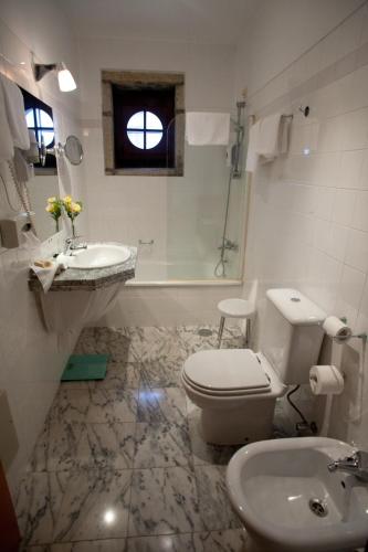 a bathroom with a toilet and a sink at Hotel Rural Quinta da Geia in Aldeia das Dez