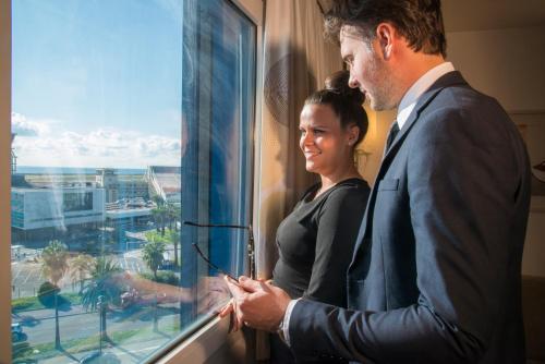 a man and a woman looking out of a window at Novotel Nice Arenas Aeroport in Nice