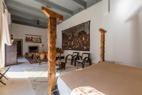 a bedroom with a bed with a wooden post at Riad Tchaikana in Marrakesh