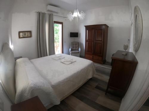 een slaapkamer met een bed, een dressoir en een raam bij Villa Sari affitta camere in La Caletta